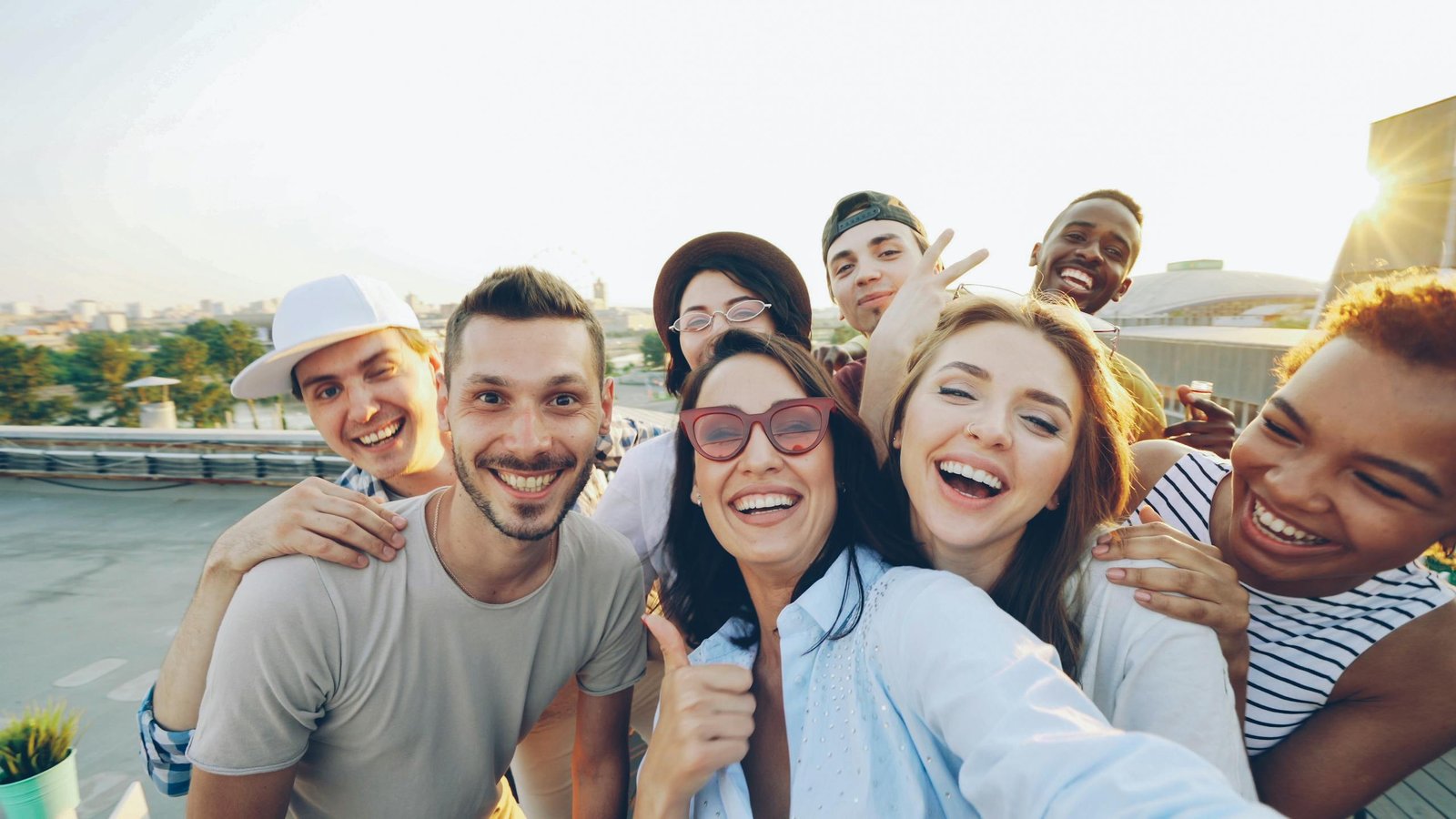Happy diverse friends taking a selfie on a rooftop in the daytime.
